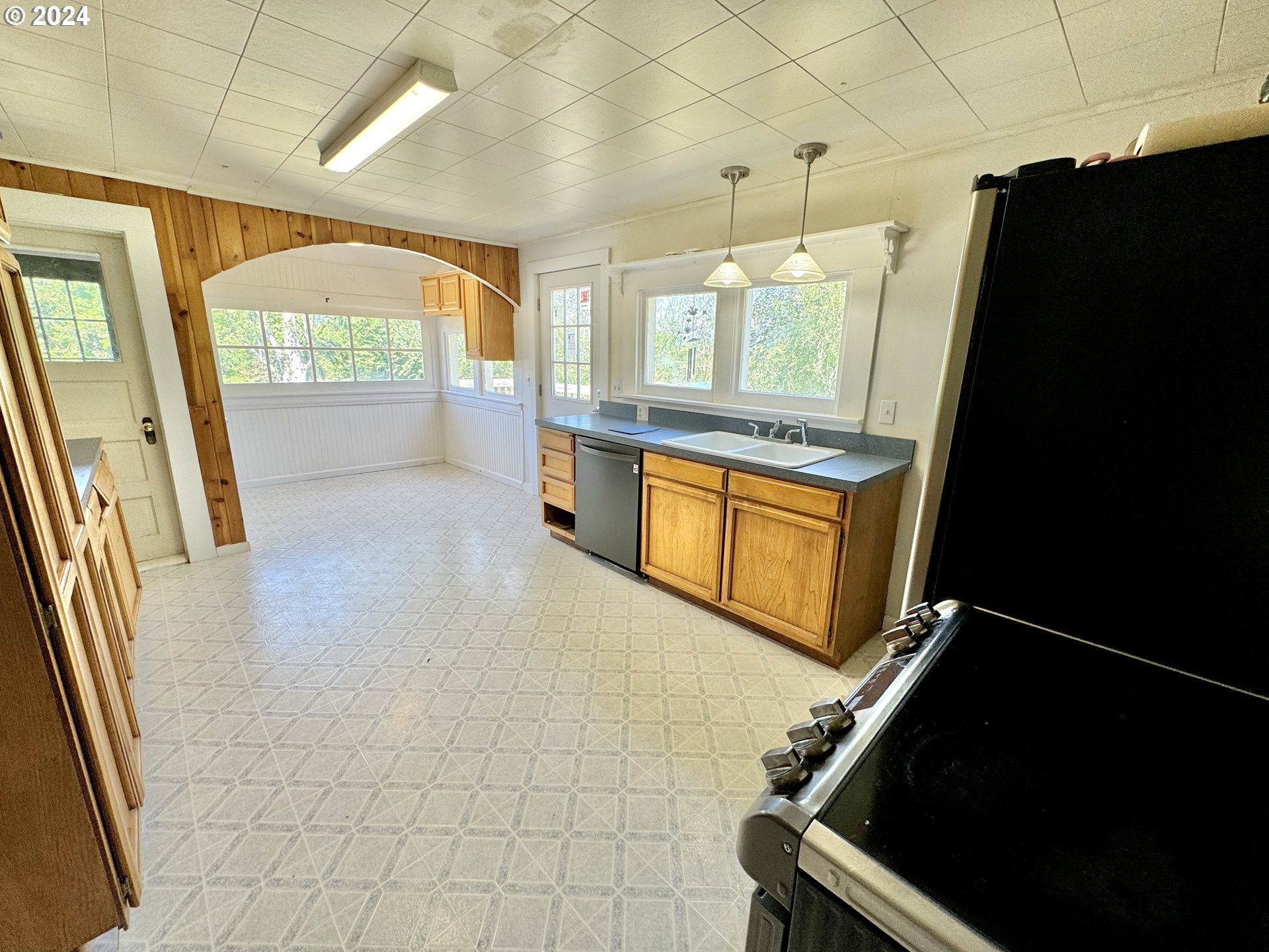 1463 Southside Road Sutherlin, OR 97479 - Photo 6 of 48 a kitchen with granite countertop white cabinets and black appliances