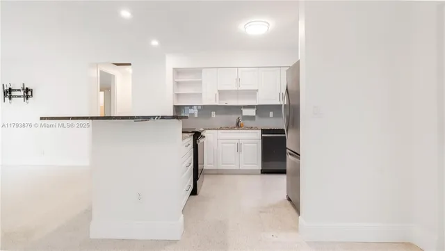 a kitchen with stainless steel appliances granite countertop a stove and a refrigerator
