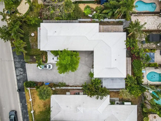 an aerial view of a house with a yard and a large tree