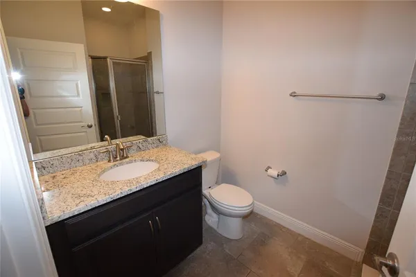 a bathroom with a granite countertop sink toilet and shower