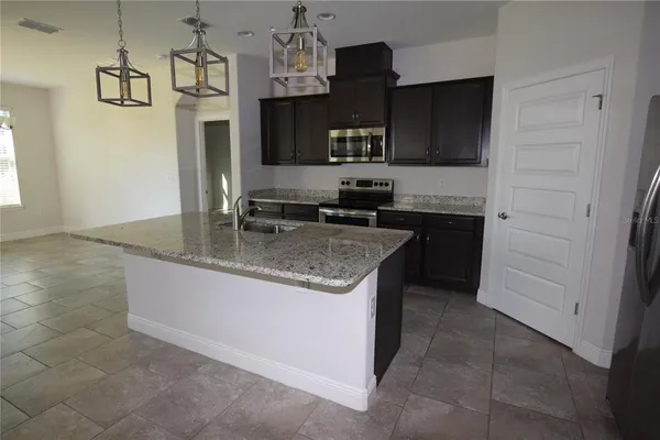 a kitchen with stainless steel appliances granite countertop a sink and a stove