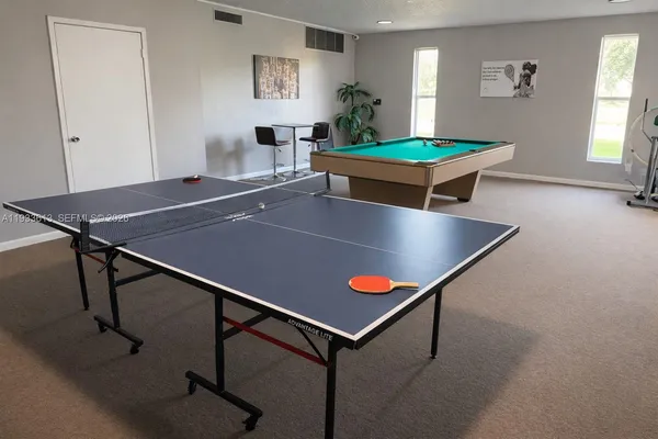 a room with pool table and windows