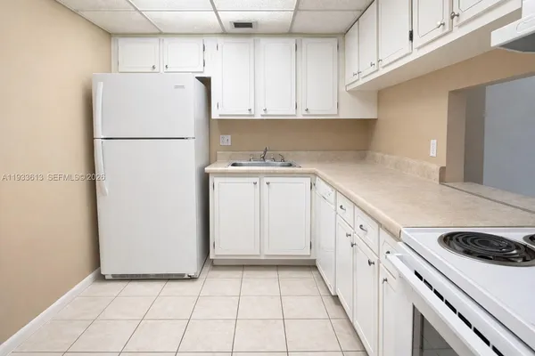 a kitchen with a refrigerator a stove top oven and cabinets
