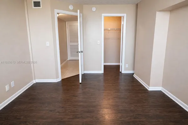 an empty room with wooden floor & closet
