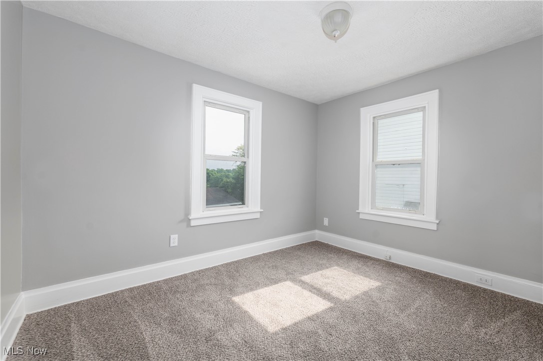 197 East Wilbeth Road Akron, OH 44301 - Photo 15 of 22 Carpeted spare room featuring plenty of natural light, baseboards, and a textured ceiling