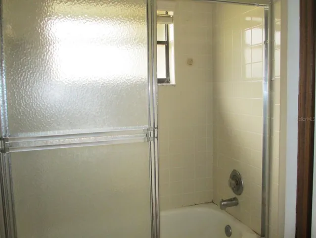 a bathroom with a glass shower door