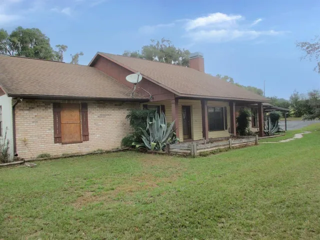 a view of a house with a yard and sitting area
