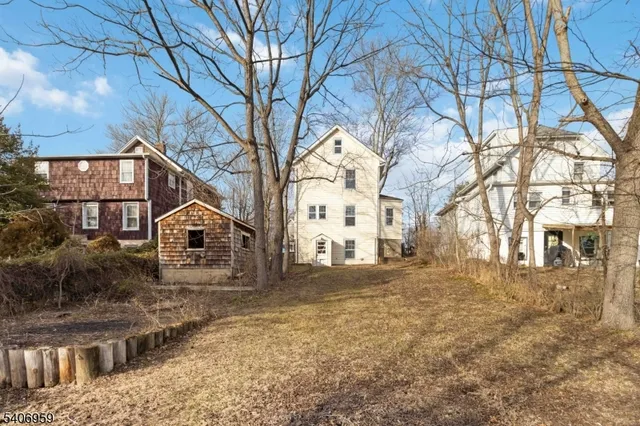 a view of a large white house with a large tree