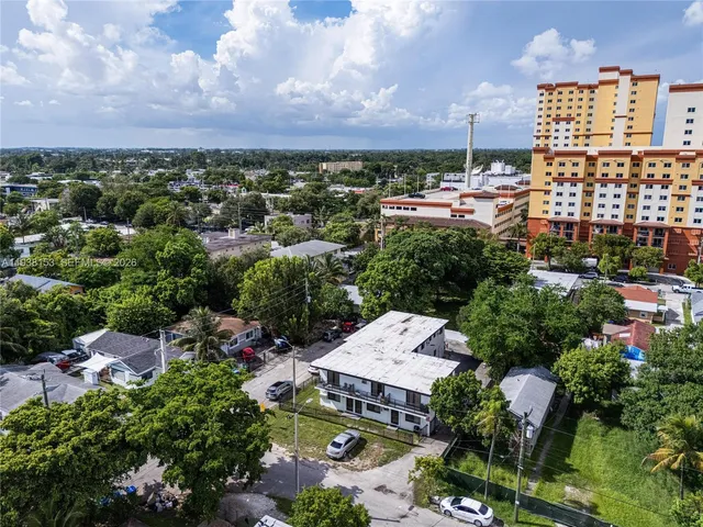 an aerial view of a city with lots of residential buildings ocean and mountain view in back