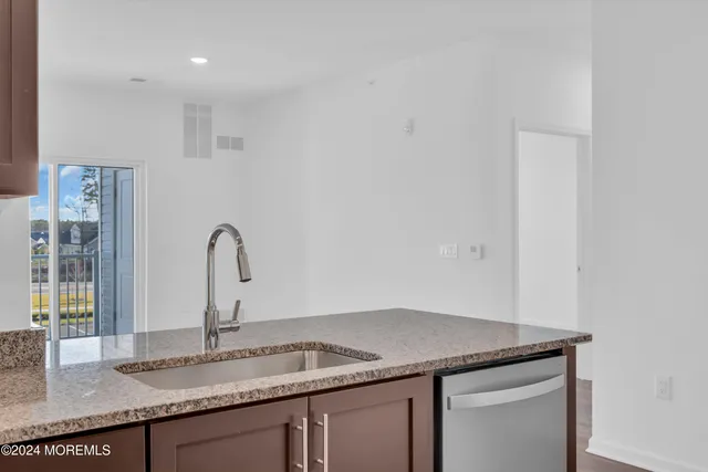 a kitchen with granite countertop a refrigerator and a sink