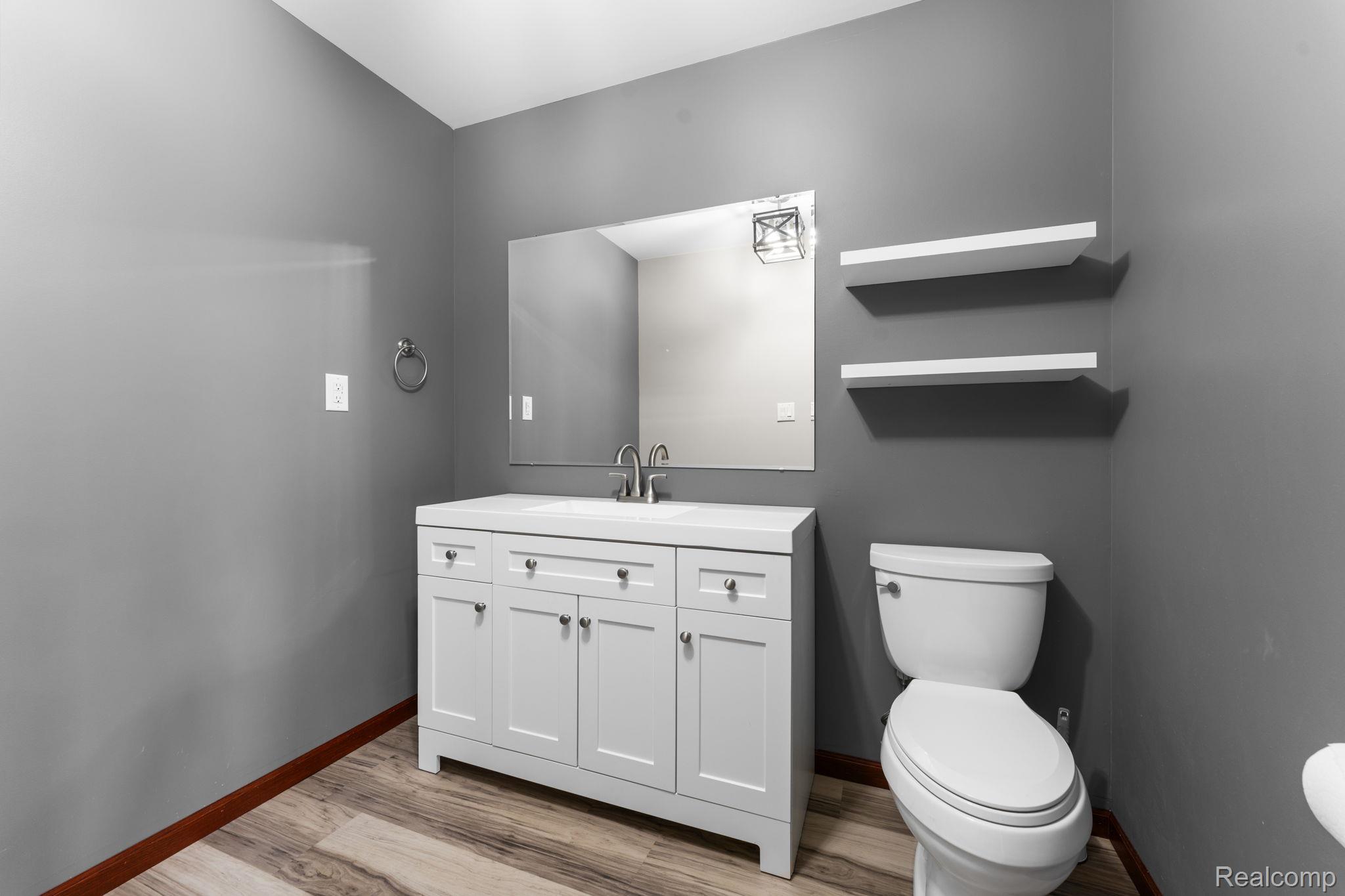 2381 Burke Road Fowlerville, MI 48836 - Photo 11 of 31 Bathroom featuring a white vanity with silver hardware, an integrated white sink, and a mounted rectangular mirror