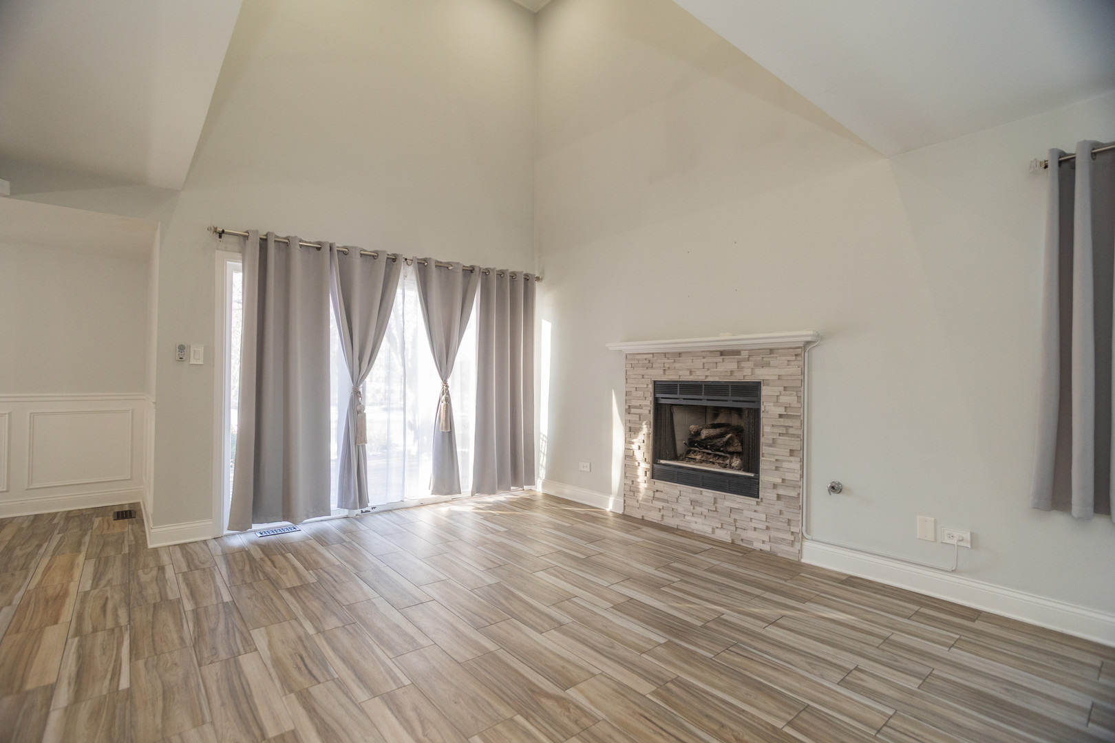 14451 South Ravinia Avenue, Unit 1 Orland Park, IL 60462 - Photo 3 of 22 an empty room with wooden floor fireplace and windows