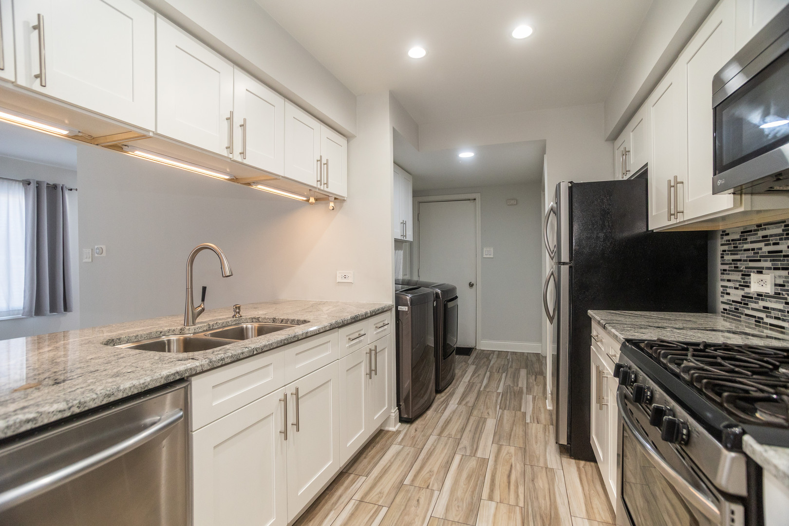 14451 South Ravinia Avenue, Unit 1 Orland Park, IL 60462 - Photo 10 of 22 a kitchen with granite countertop a sink stainless steel appliances and cabinets