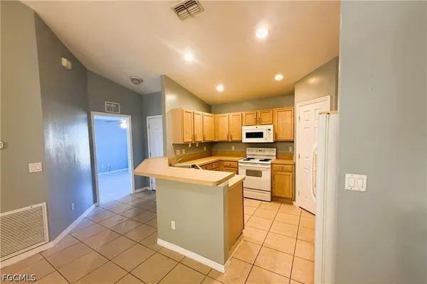a kitchen that has a sink a stove top oven a refrigerator and a counter top space