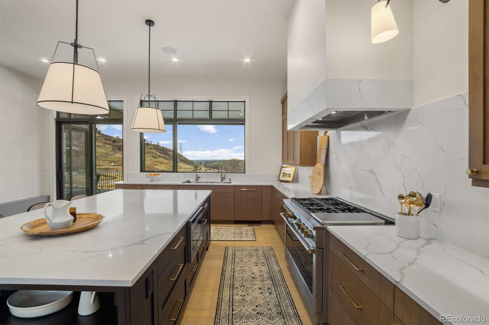 5132 Mount Glennon Way Morrison, CO 80465 - Photo 8 of 40 a kitchen with stainless steel appliances granite countertop a stove a sink a refrigerator and a wooden floor