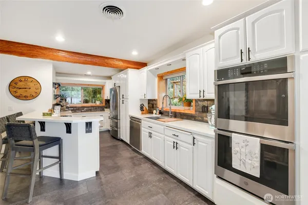 a kitchen with stainless steel appliances kitchen island granite countertop a stove and cabinets