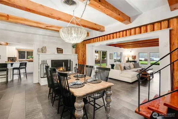 a dining room with furniture a fireplace and a large mirror