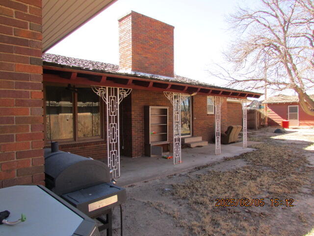 608 West Ave J Muleshoe, TX 79347 - Photo 4 of 25 a view of a patio with table and chairs a barbeque with wooden fence