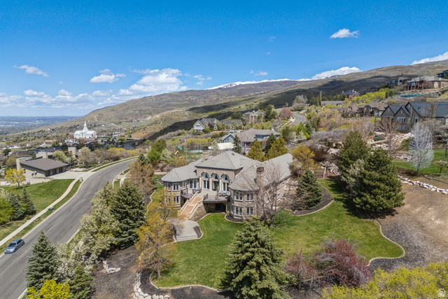 1714 Ridge Point Drive Bountiful, UT 84010 - Photo 6 of 132 Stone-clad exterior, multi-level structure, paved driveway, mature trees, and landscaped grounds