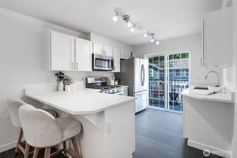 a kitchen with kitchen island a sink table and chairs