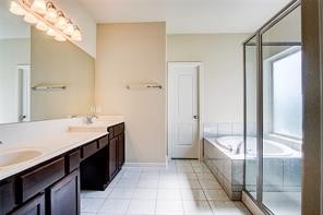 2723 Intrepid Trail Rosenberg, TX 77471 - Photo 18 of 30 The impeccable master bathroom showcases tile floors, a walk-in closet, dual sinks, a garden soaking tub and a walk-in shower.