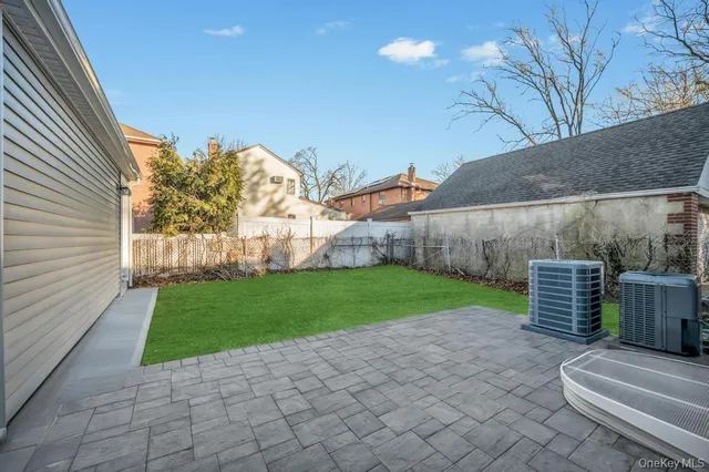 a view of a backyard with couches plants and large tree