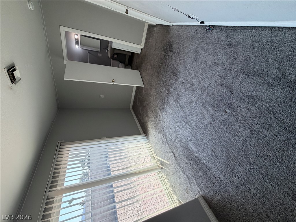 2820 South Sandhill Road, Unit A Las Vegas, NV 89121 - Photo 15 of 26 A well-maintained carpeted room with neutral walls and natural illumination from a large window.