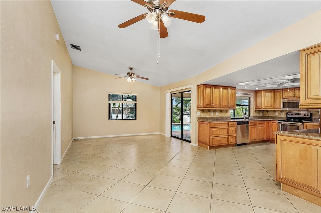 17516 Ingram Road Fort Myers, FL 33967 - Photo 20 of 26 a large kitchen with stainless steel appliances a stove a sink dishwasher and a refrigerator