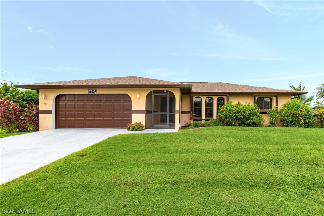 17516 Ingram Road Fort Myers, FL 33967 - Photo 2 of 26 a front view of a house with a garden and yard