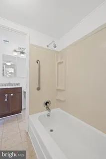 a bathroom with a tub a sink and mirror