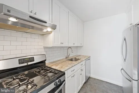 a white stove top oven sitting inside of a kitchen