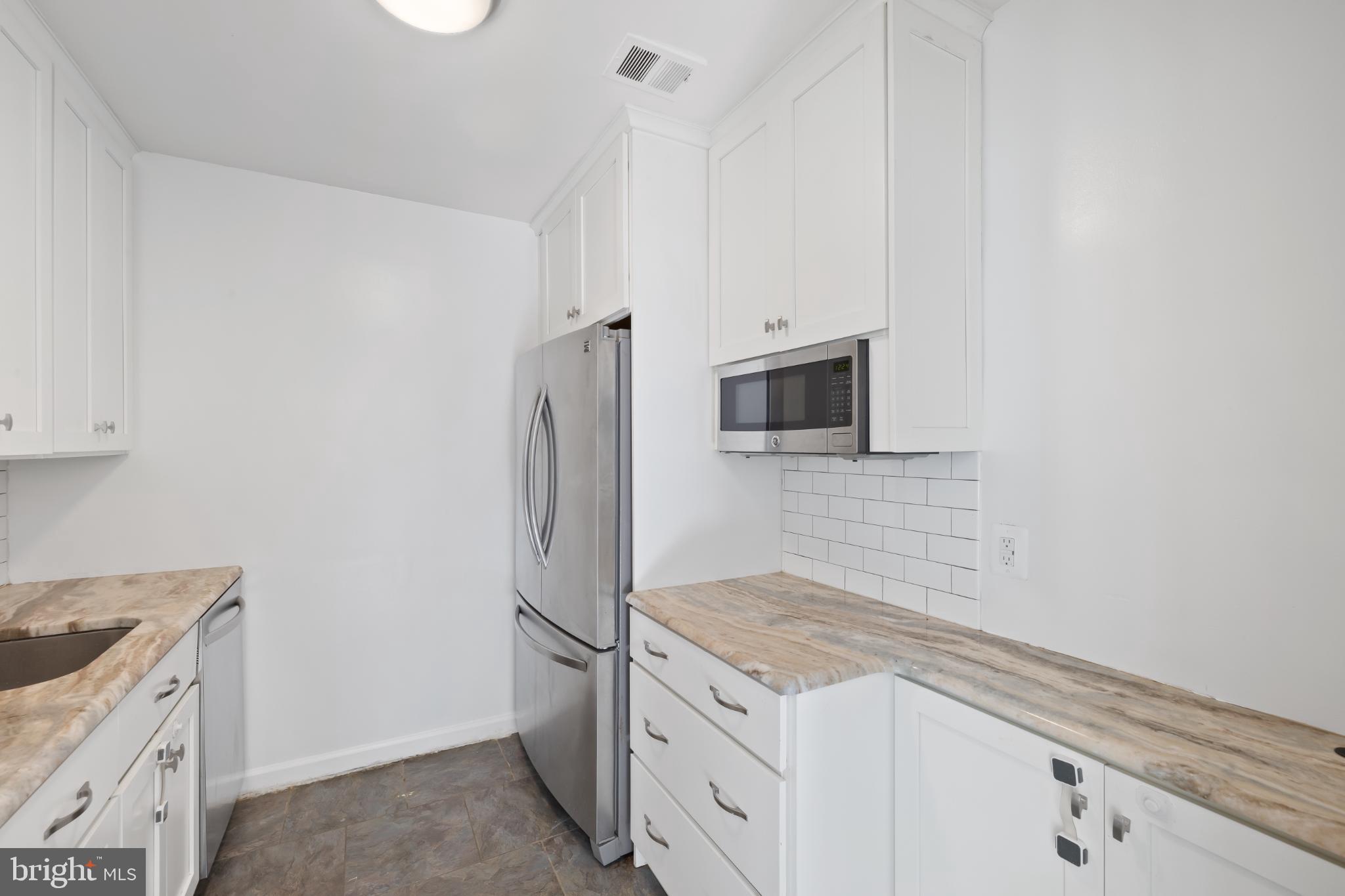 10572 Twin Rivers Road, Unit D1 Columbia, MD 21044 - Photo 7 of 24 Modern kitchen with sleek white cabinetry.