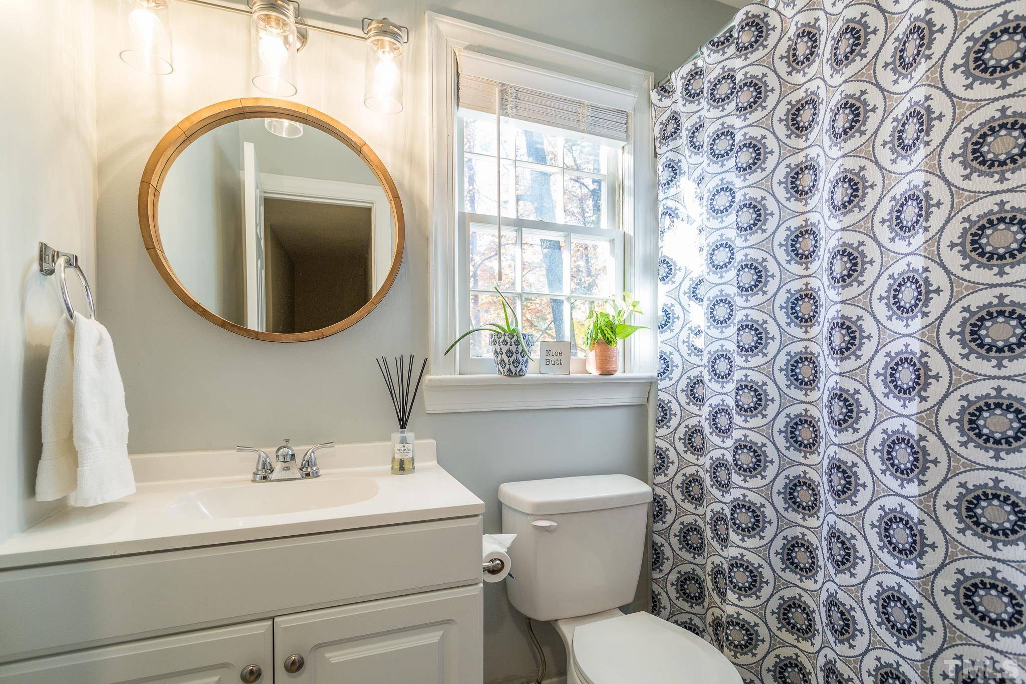 7013 Sandringham Drive Raleigh, NC 27613 - Photo 15 of 25 a bathroom with a toilet sink and mirror