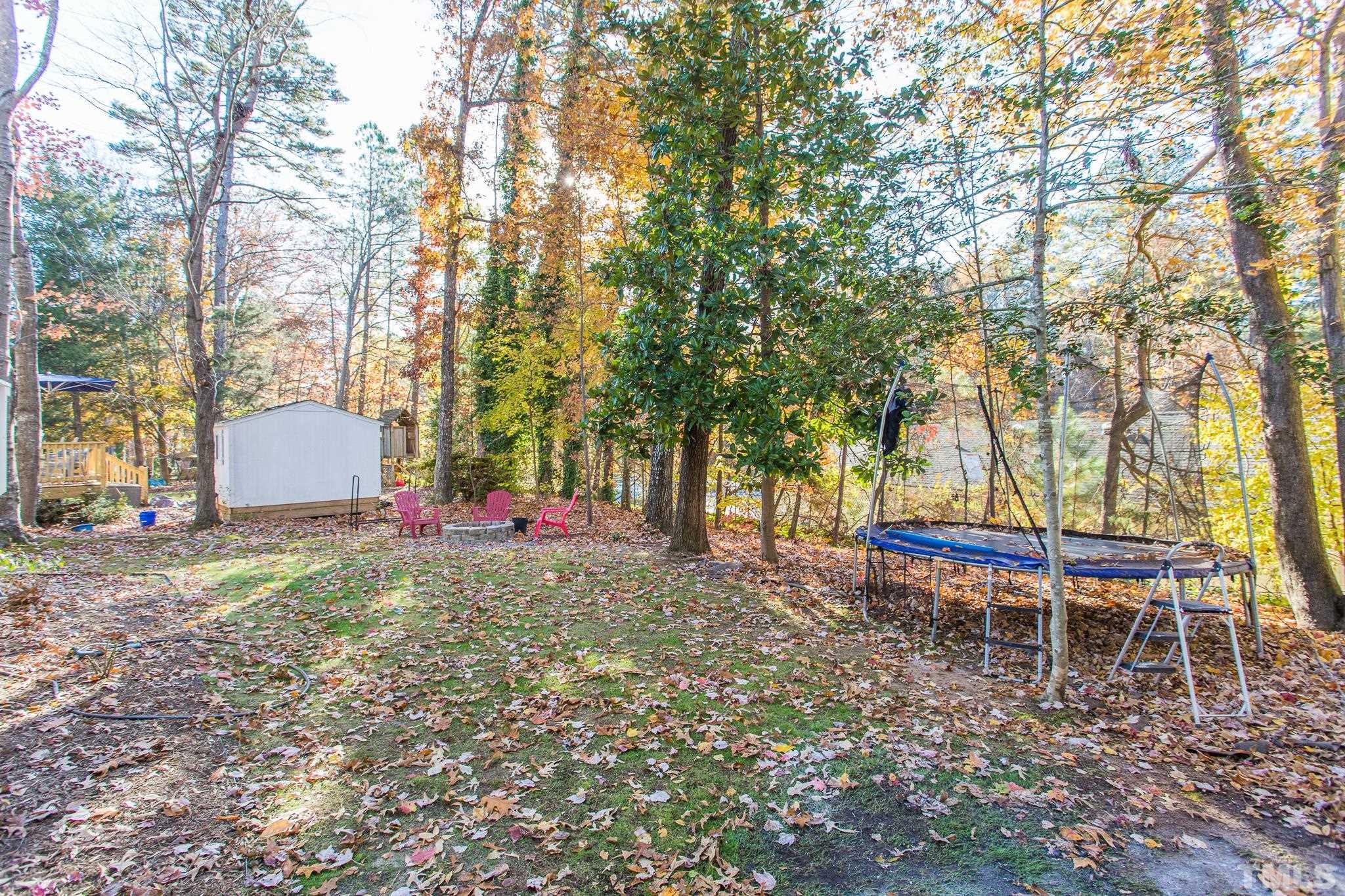 7013 Sandringham Drive Raleigh, NC 27613 - Photo 21 of 25 a backyard of a house with table and chairs