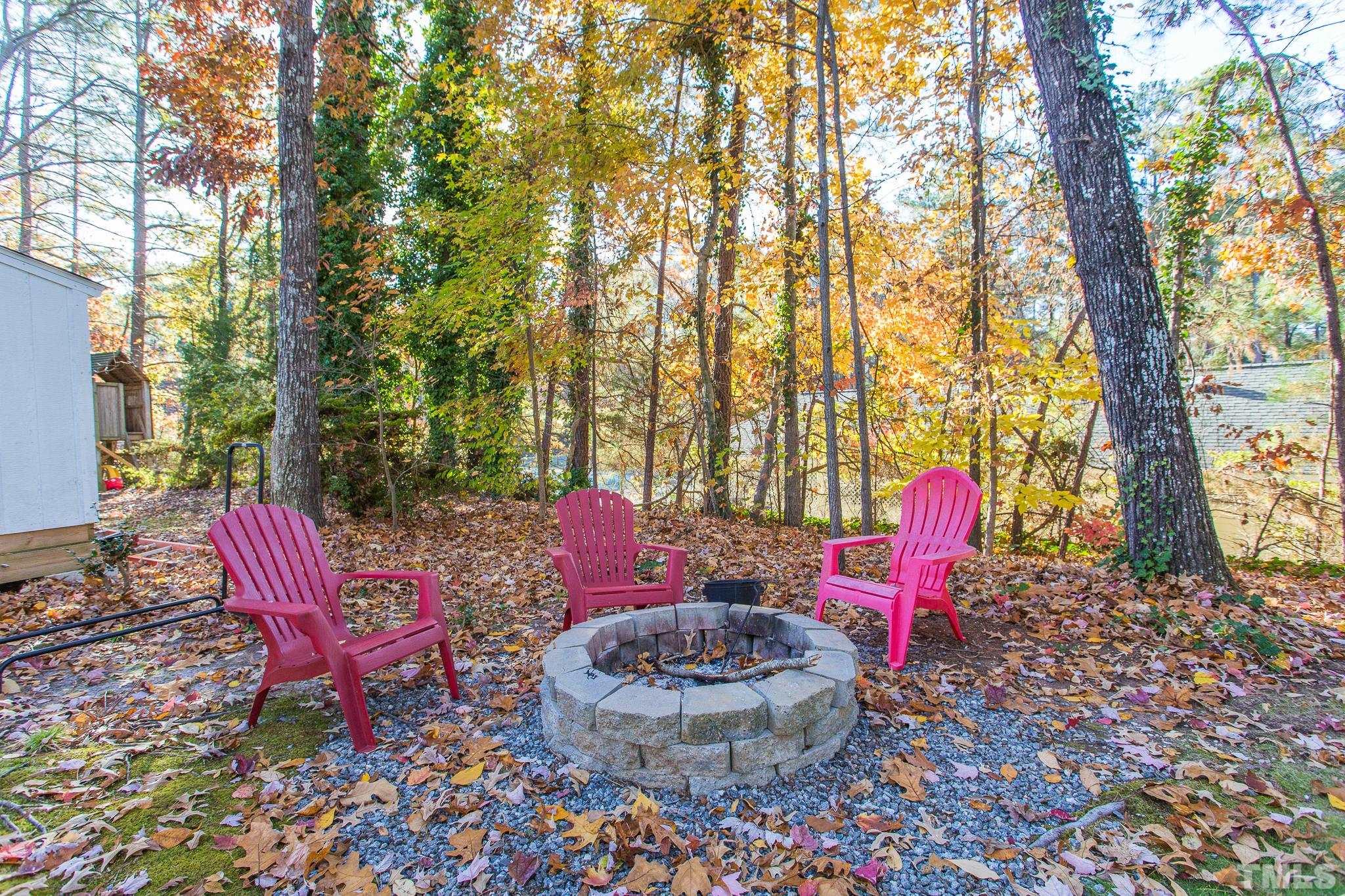 7013 Sandringham Drive Raleigh, NC 27613 - Photo 22 of 25 a view of a backyard with table and chairs potted plants and large tree
