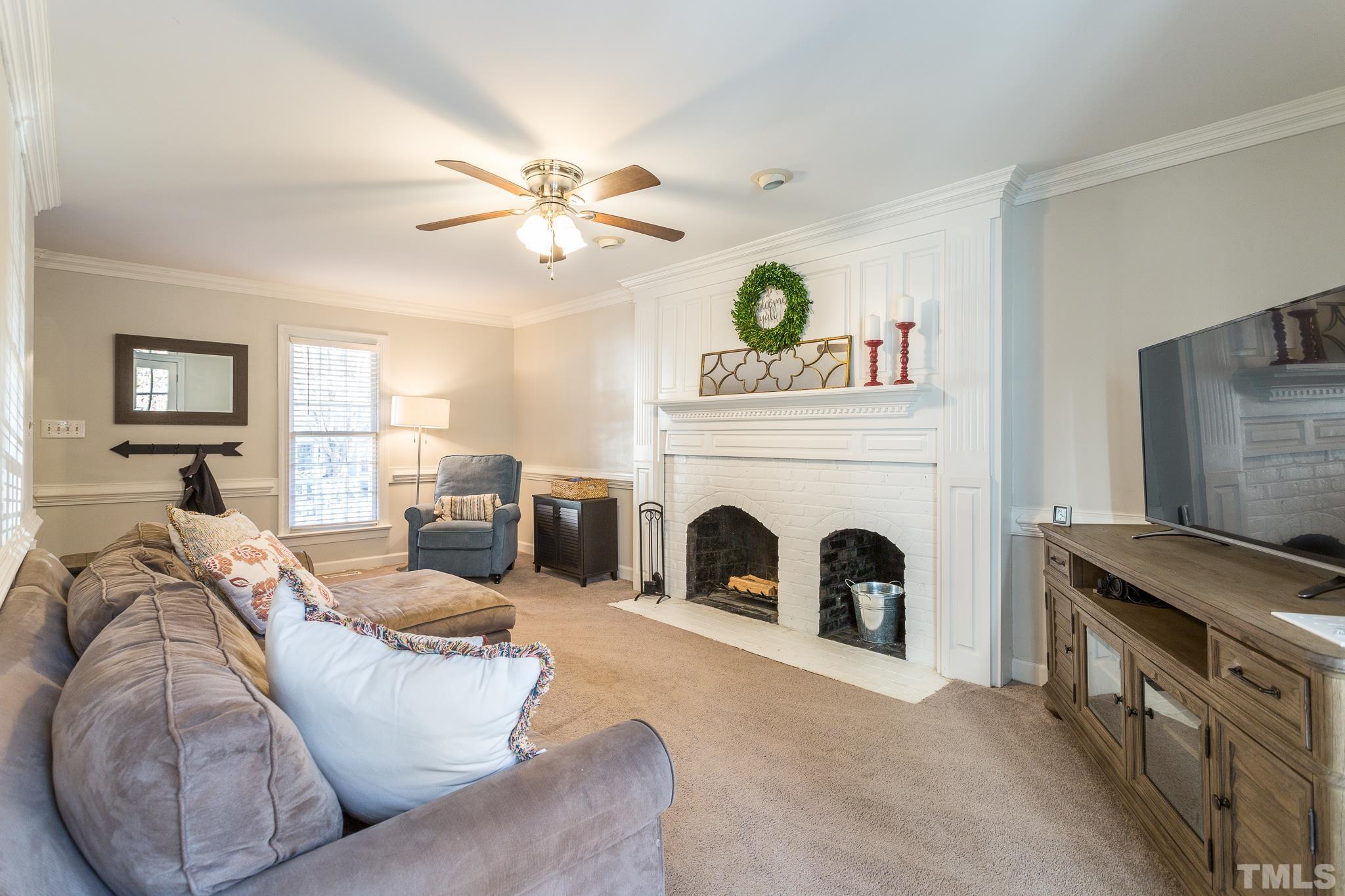 7013 Sandringham Drive Raleigh, NC 27613 - Photo 4 of 25 a living room with furniture a fireplace and a window