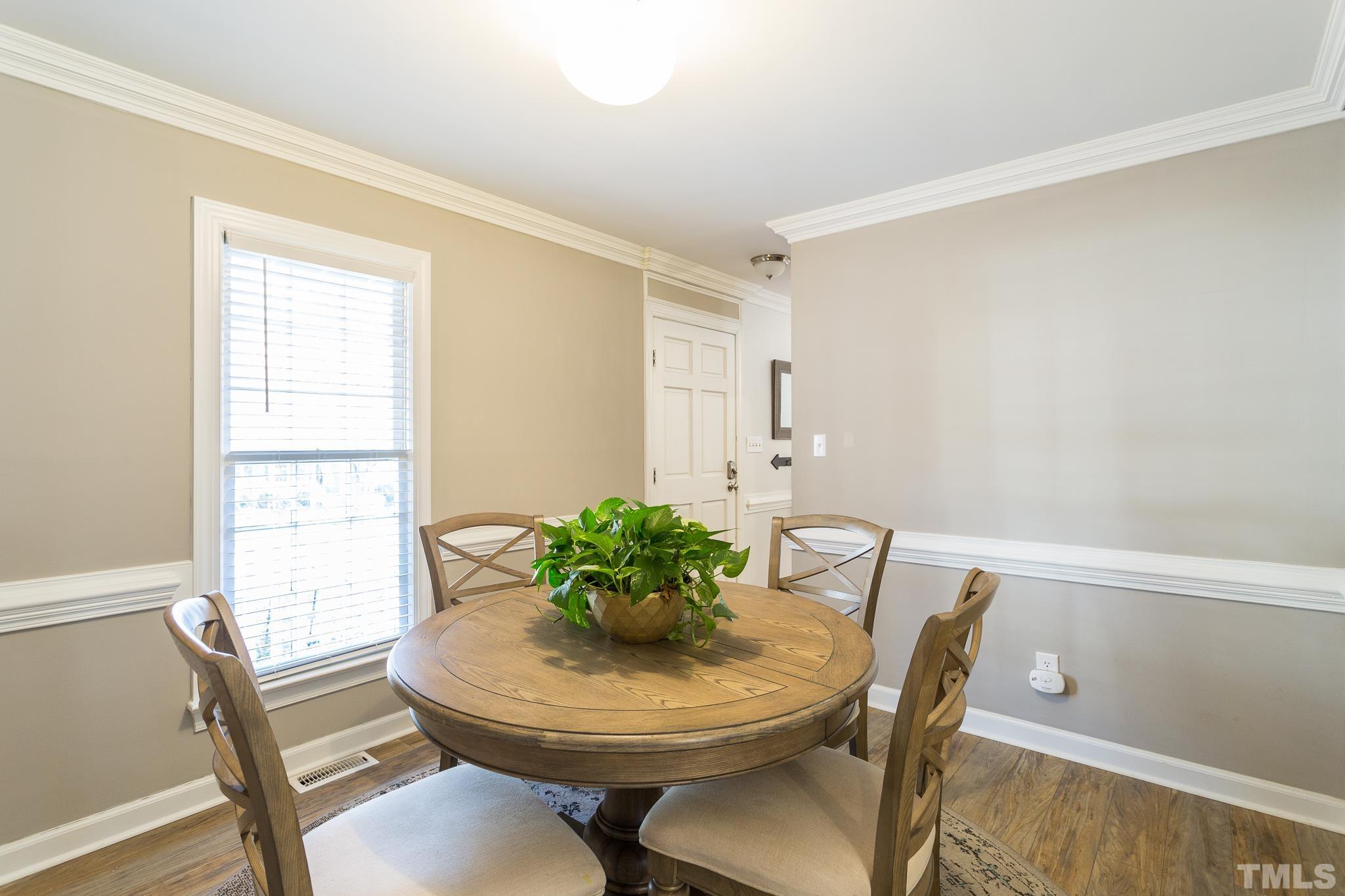 7013 Sandringham Drive Raleigh, NC 27613 - Photo 6 of 25 a view of a dining room with furniture and wooden floor