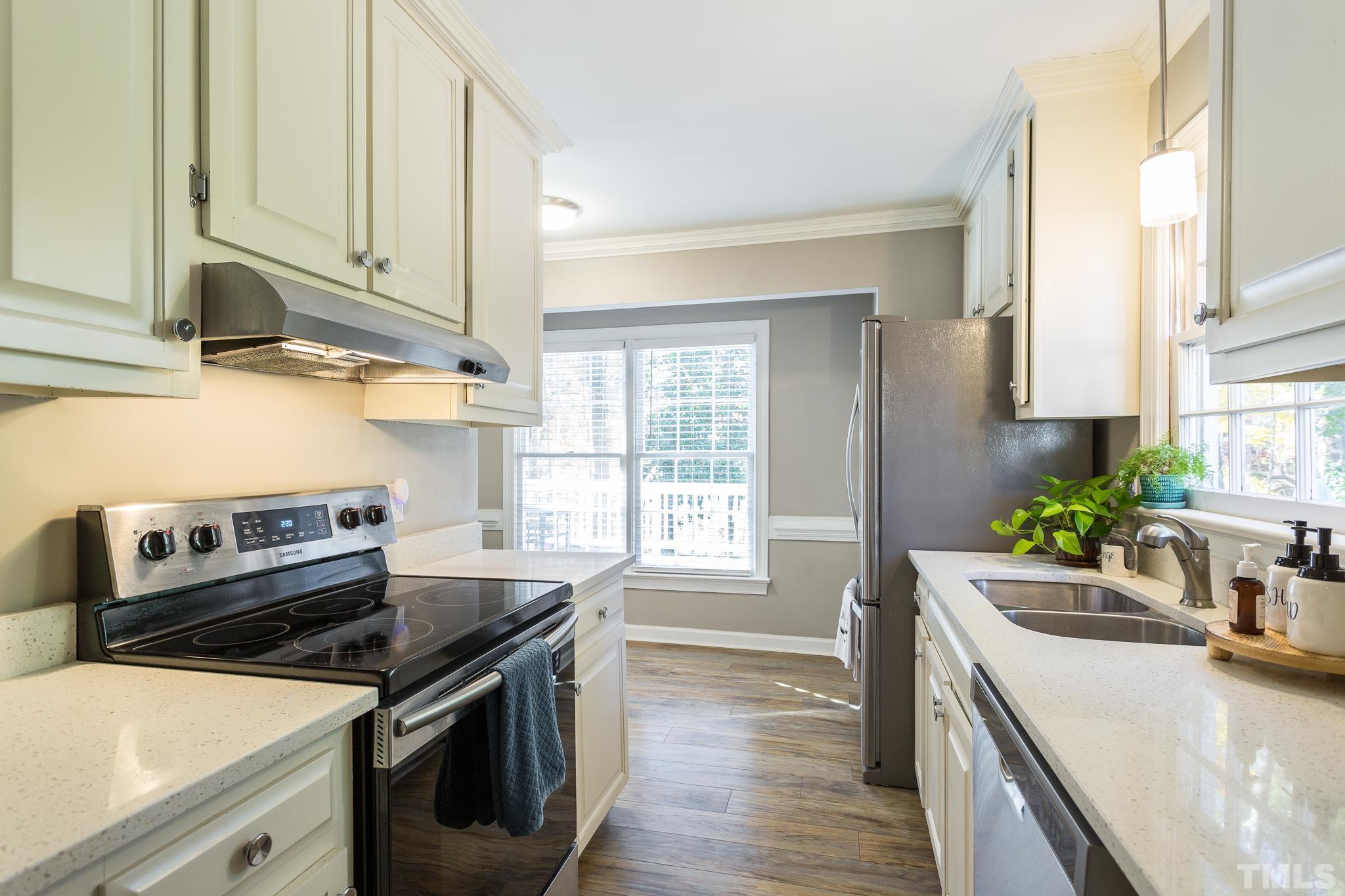 7013 Sandringham Drive Raleigh, NC 27613 - Photo 7 of 25 a kitchen with a sink stove and cabinets