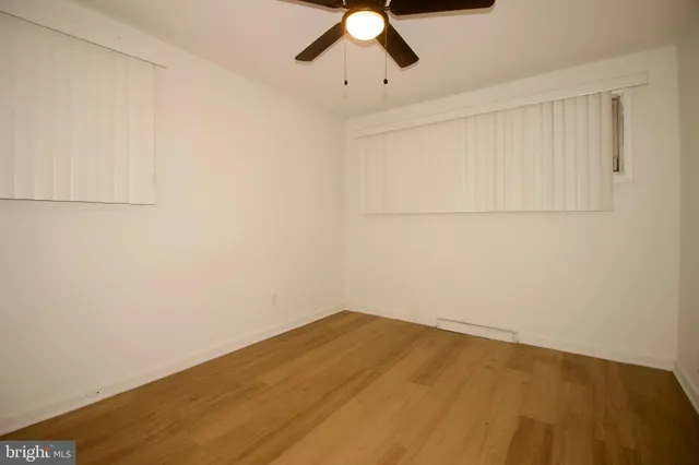 an empty room with a ceiling fan and carpet