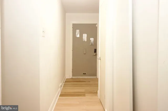 a view of a hallway with wooden floor