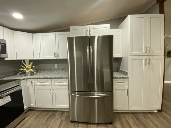 a kitchen with stainless steel appliances a refrigerator and cabinets