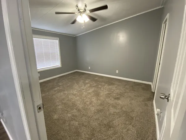 en empty room with windows and fan