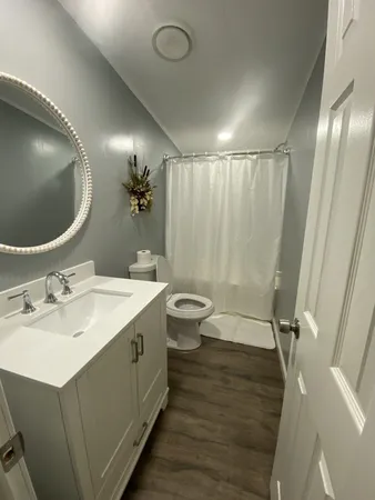 a bathroom with a sink mirror vanity and toilet