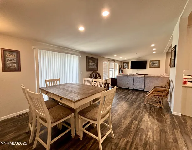 a living room with a table chairs and a kitchen view