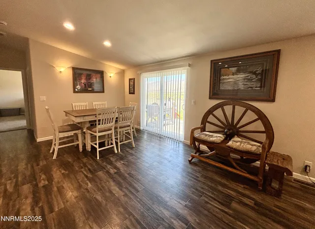 a dining room with wooden floor a glass table and windows