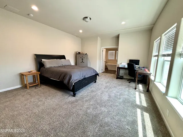 a spacious bedroom with a bed and a large window