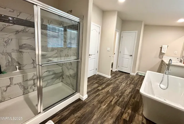 a bathroom with a granite countertop sink a mirror and shower
