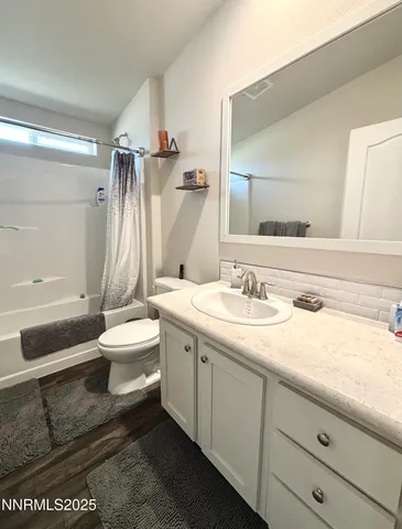a bathroom with a granite countertop sink a toilet and a mirror
