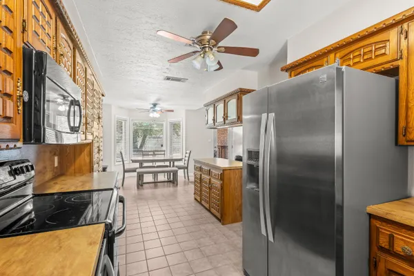 a kitchen with stainless steel appliances granite countertop a refrigerator a stove and a sink