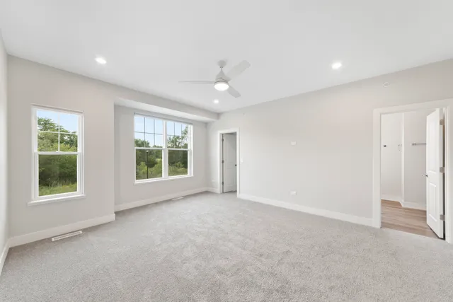 an empty room with windows and closet